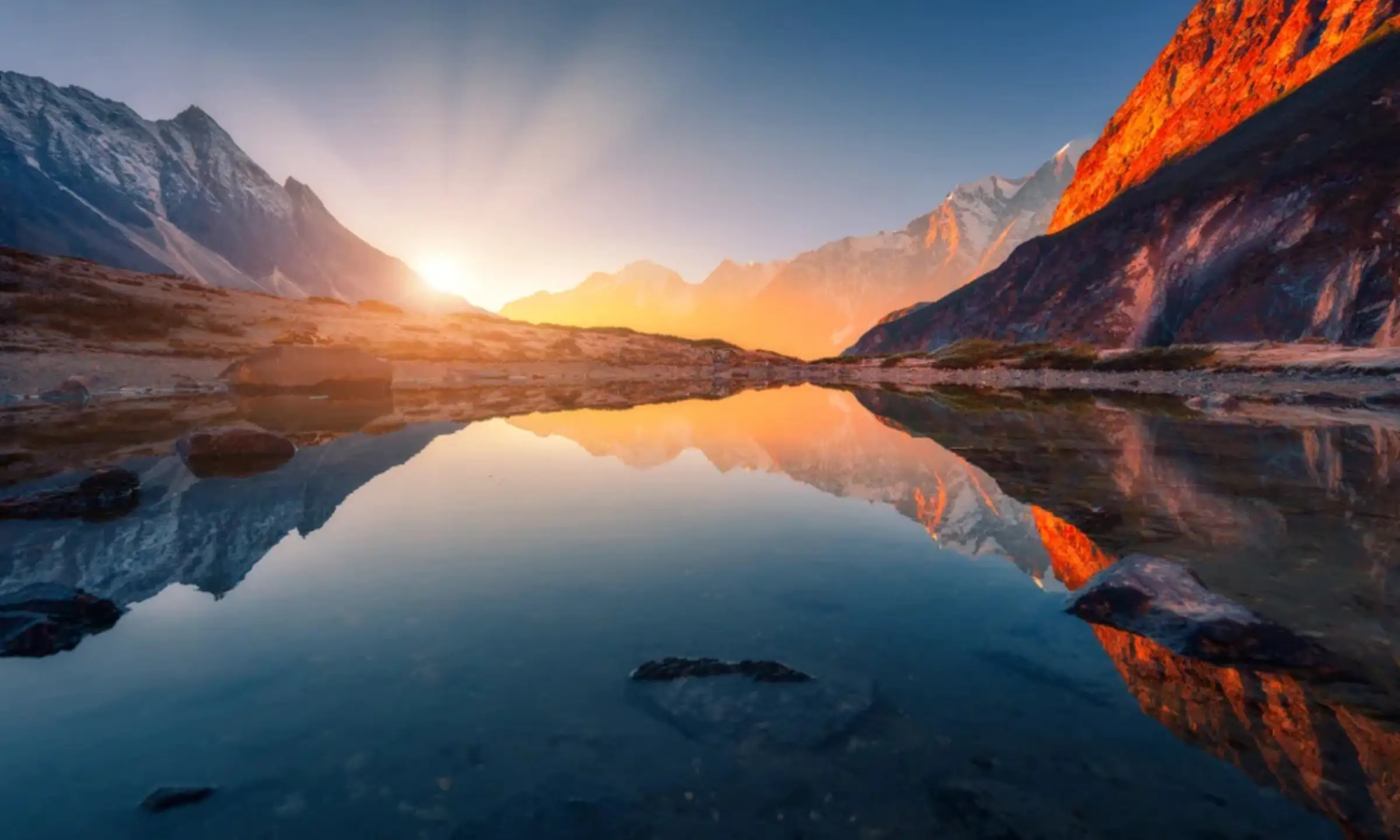 Mountain range reflected in an alpine lake at sunrise